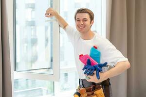 joven hombre limpieza ventanas en el casa foto