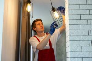 man changing led ceiling lamp in new house photo