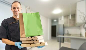 papel bolsillo y comida contenedores en manos de un sonriente repartidor. calidad Servicio de un restaurante. foto
