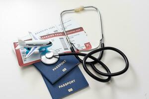 health insurance in travel concept. medical care abroad. stethoscope, toy airplane and passports photo