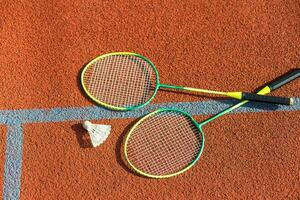 Badminton rackets and feather shuttlecock on the court photo