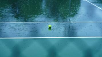 One netball lying on the wet field in the rainy day photo