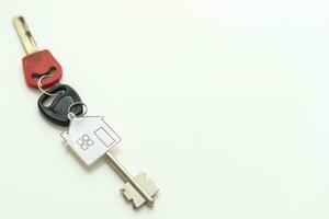 key chain with house symbol and keys on white background, Real estate concept photo