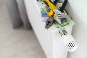 A stack of money on the background of the radiator. Expensive utilities. photo