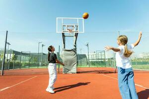 concepto de Deportes, aficiones y sano estilo de vida. joven personas jugando baloncesto en patio de recreo al aire libre foto