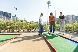 Mother and her little daughter practicing to hit the ball at the course photo