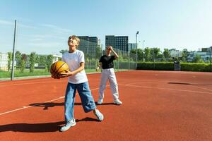 concepto de Deportes, aficiones y sano estilo de vida. joven personas jugando baloncesto en patio de recreo al aire libre foto
