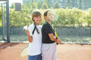 joven chicas, Atletas sacudida manos antes de juego sesión. jugando tenis en calentar soleado día a abierto aire tenis corte. concepto de deporte, pasatiempo, activo estilo de vida, salud, resistencia y fortaleza, anuncio foto