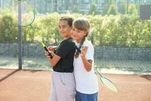 Two girls with badminton rackets on the football field. photo