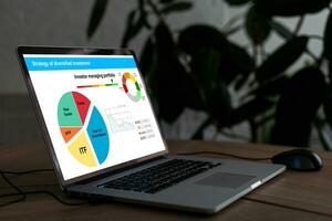 Office desk with graphs and charts on a laptop photo