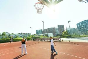 concepto de Deportes, aficiones y sano estilo de vida. joven personas jugando baloncesto en patio de recreo al aire libre foto