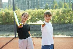 Two girls with badminton rackets on the football field. photo