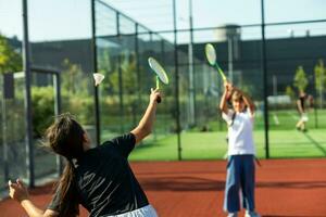 contento deportivo elemental colegio años chica, niño jugando bádminton, participación un raqueta haciendo gracioso caras, retrato, estilo de vida. Deportes, ejercicio y sano al aire libre ocupaciones ocio concepto, uno persona foto