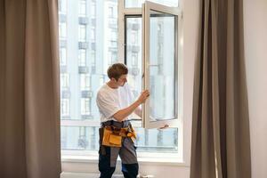 trabajador de la construcción instalando ventana en casa foto