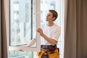 Construction worker installing window in house. photo