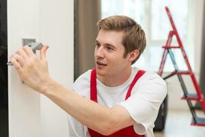 Young man fixing the door in house. photo