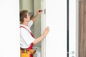 Young man fixing the door in house. photo