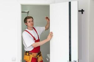 Portrait Young Male Carpenter Repairing Door Lock photo