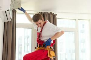 Service man is cleaning, repair and maintenance of air conditioner photo