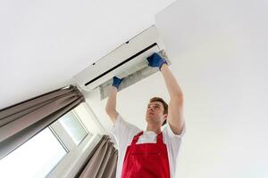 Service man is cleaning, repair and maintenance of air conditioner photo