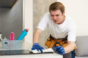 Attractive caucasian man cleaning the table in the kitchen photo