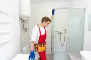 Plumber installing a shower cabin in bathroom photo