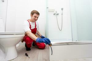 Plumber installing a shower cabin in bathroom photo