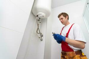 Professional engineer doing a boiler inspection at home photo