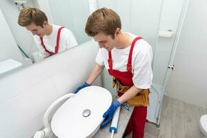 a worker installs a wash basin in a bathroom. photo