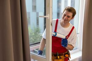 Worker installing plastic window indoors, closeup view photo