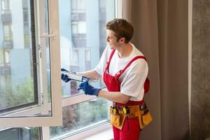 Construction worker installing window in house. photo