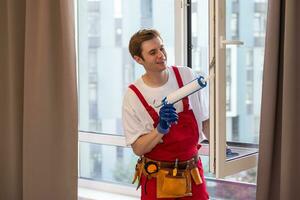 Construction worker installing window in house photo