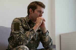 Thoughtful young handsome soldier in military uniform. photo