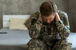 Thoughtful young handsome soldier in military uniform. photo