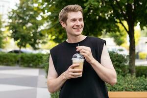 Hipster holding iced coffee in the city. photo