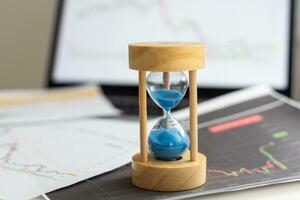 Best time for investment. Hourglass, financial charts and calculator. photo