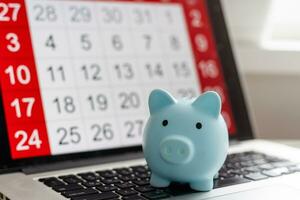 Saving money concept. Piggy bank on calculator. photo