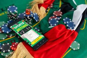 online casino concept, playing cards, dice chips and smartphone with copyspace on the green table. view from above. banner template layout mockup for online casinos and gambling. photo