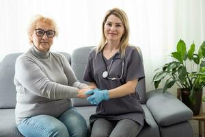 Happy patient is holding caregiver for a hand while spending time together. photo