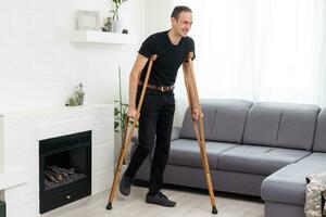 Young man with axillary crutches photo