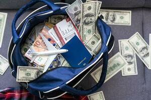 Air tickets, passports, money and toy plane on table photo