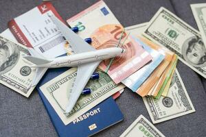 Air tickets, passports, money and toy plane on table photo