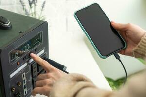 Charging mobile phone battery with wireless charging device in the table. Smartphone charging on a charging pad. Mobile phone near wireless charger Modern lifestyle technology. photo