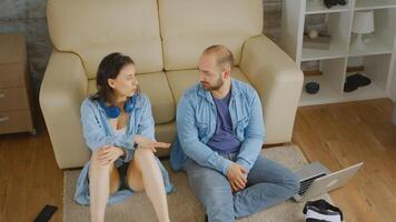 Top view of couple having a conversation sitting near sofa on carpet. photo