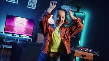 Talented gen z influencer doing viral dance choreography, creating content to generate views and engagement. Happy child having fun dancing around neon lit living room, entertaining audiences video