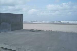 partes de hormigón edificio a el playa de el mar ai generativo foto