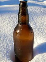 botella de cerveza en el nieve ai generativo foto