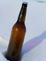 botella de cerveza en el nieve ai generativo foto