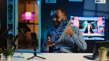 Content creator filming technology review of newly released DJ controller, unboxing it and presenting specifications to audience. Influencer showing sound mixer equipment to followers photo