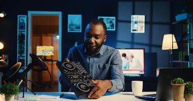 Artist filming DJ mixing tutorial showing examples of sampling on sound controller to audience. Viral internet star showing modern musical equipment to subscribers in home studio photo